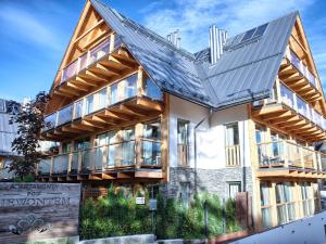 a house with a metal roof on top of it at VisitZakopane - Dolomite SPA Apartment in Zakopane