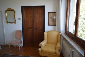 Habitación con silla, espejo y puerta en Villa Il Respiro, en Zoagli