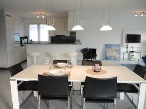Bicledro في أسكونا: غرفة طعام مع طاولة بيضاء وكراسي
