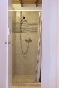 uma casa de banho com um chuveiro e uma porta de vidro em Sára Vendégház em Szentes