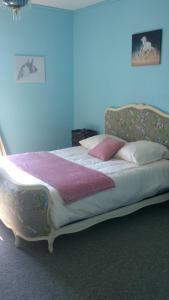 un letto in una camera con parete blu di Maison Du Cheval a Chalais
