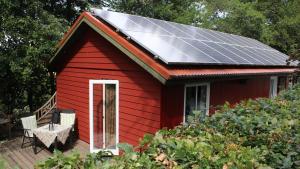 a red house with solar panels on the roof at Ferienhaus Eggert in Lindewitt