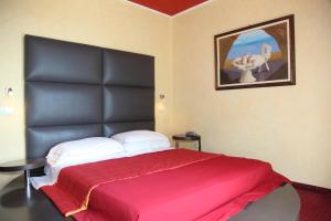 a bedroom with a large bed with a black headboard at Hotel Soraya in Lignano Sabbiadoro