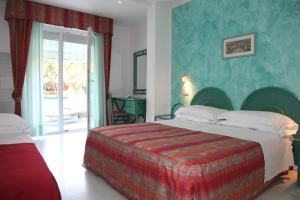 - une chambre avec un grand lit et une porte coulissante en verre dans l'établissement Hotel Soraya, à Lignano Sabbiadoro