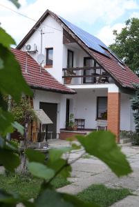 uma casa branca com painéis solares no telhado em Sára Vendégház em Szentes