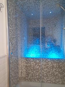 ein Bad mit einer Dusche mit blauen Lichtern in der Unterkunft L'Attico di San Saba in Rom