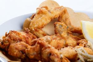 eine Schüssel gebratenes Essen mit Chips und ein Stück Zitrone in der Unterkunft Locanda con cucina Il Tornado in Gramignazzo