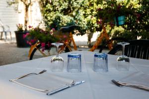 uma mesa com uma toalha de mesa branca e óculos em Locanda con cucina Il Tornado em Gramignazzo