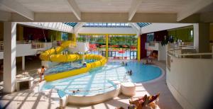 un parc aquatique intérieur avec un toboggan dans l'établissement Hotel Sonnenpark & Therme included - auch am An- & Abreisetag!, à Lutzmannsburg