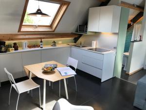 a kitchen with a table and chairs and a sink at Rap 'n Holiday Home in Sint-Denijs-Westrem