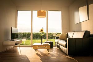 ein Wohnzimmer mit einem Sofa und einem TV in der Unterkunft Ferienwohnen im Ziegelfeld in Niederrotweil