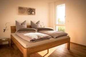 ein Schlafzimmer mit einem Bett mit Kissen und einem Fenster in der Unterkunft Ferienwohnen im Ziegelfeld in Niederrotweil