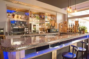a bar with two stools in front of it at The Originals Boutique, Hôtel du Pont Roupt, Mende in Mende