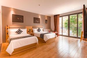 een slaapkamer met twee bedden en een groot raam bij Aiden Saigon Hotel in Ho Chi Minh-stad