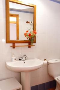 a bathroom with a sink and a mirror and a toilet at Casa Enpiera II - Turistrat in Cinctorres