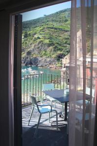 a balcony with a table and chairs and a view of the ocean at MADA Charm Apartments Terrace&Carugio in Vernazza