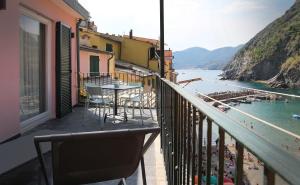 a balcony with a table and a view of the water at MADA Charm Apartments Terrace&Carugio in Vernazza