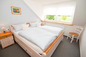 Schlafzimmer mit einem großen Bett und einem Fenster in der Unterkunft Ferienhof Kai Hansen in Rettin