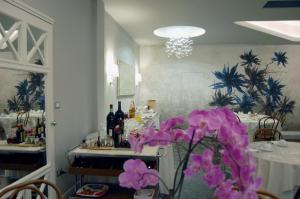 モンテカティーニ・テルメにあるHotel Brasileの紫の花が飾られたテーブルが備わる部屋