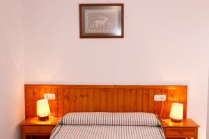 a bedroom with a bed and two lamps on night stands at Casa Enpiera II - Turistrat in Cinctorres