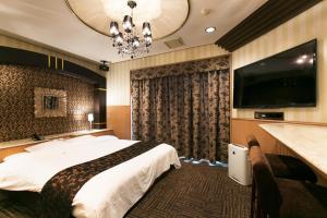 Habitación de hotel con cama y TV de pantalla plana. en Hotel Atlantis Otsu (Adult Only) en Otsu