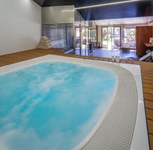 a large swimming pool in a house with a large room at Hôtel Restaurant & Spa Plaisir in Le Bois-Plage-en-Ré