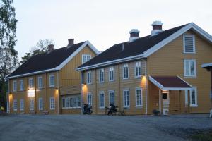 a white house with a red brick building at Granavolden Gjæstgiveri in Gran