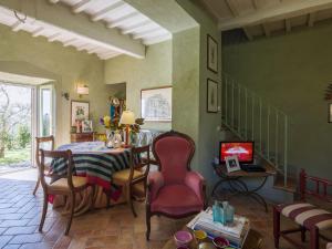 uma sala de jantar com uma mesa e cadeiras e uma televisão em Belvilla by OYO La Noce em Cortona