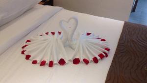 een witte zwanenversiering op een bed met rode harten bij Gold Boutique Hotel in Seremban