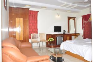 a bedroom with a bed and a couch and a table at Sri Sarvesha JS Palace temple view in Tiruvannāmalai