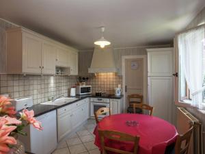 a kitchen with a table with a red table cloth at Holiday home with private pool near Sarlat in Carlux