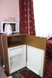 a small kitchen with a microwave and a refrigerator at Мини готель in Ternopil