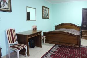 a bedroom with a bed and a desk and chairs at Мини готель in Ternopil