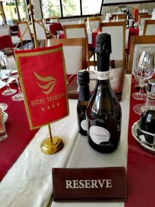 a bottle of wine on a table in a restaurant at Hotel Trebjesa in Nikšić