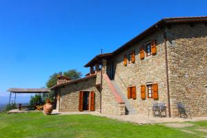 une grande maison en pierre avec une cour herbeuse dans l'établissement Agriturismo Casavecchia, à Castiglion Fibocchi