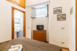 a bedroom with a bed and a television and a window at Pilly House Vucciria in Palermo