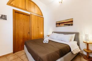 a bedroom with a bed with a wooden door at Pilly House Vucciria in Palermo