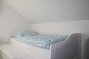 Una cama blanca con una manta azul. en Jawa Organik, en Sontheim an der Brenz