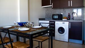 - une cuisine avec une table et un lave-linge dans l'établissement Apartamento en la Magalona, à Icod de los Vinos