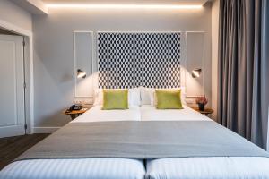 1 dormitorio con 1 cama blanca grande con almohadas verdes en Intelier Victoria, en San Sebastián