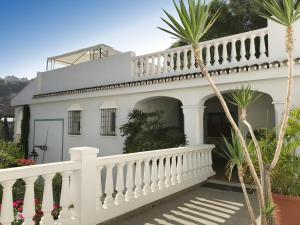 a white house with a white fence and palm trees at APARTAMENTOS LA MUNDIAL - Alojamiento en Málaga capital in Málaga