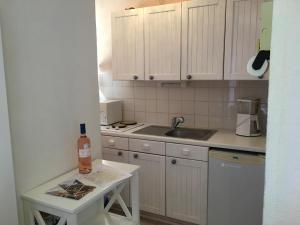 a small kitchen with white cabinets and a sink at Villa Thermae in Gréoux-les-Bains