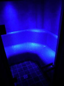 baño con bañera cubierta de luces azules en Chalet Claire, en Grimentz