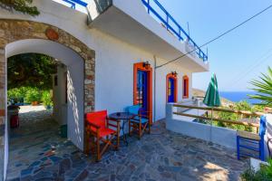 a patio with chairs and a table with a view of the ocean at ARTEMIS STUDIO - NAS in Armenistis