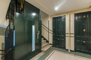 korytarz z dwoma zielonymi drzwiami i schodami w obiekcie Zurbano Madrid - Tu Refugio Sofisticado en la Ciudad w Madrycie