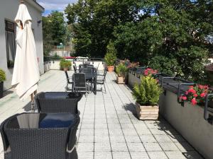 a patio with chairs and an umbrella and flowers at Pension Jana - Domov Mládeže in Prague