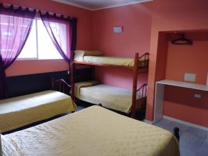 a room with three bunk beds and a window at Hotel Atlantic in Mar del Plata