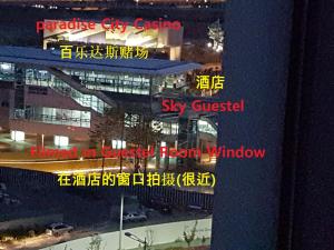 a view of a city at night with signs on a building at Sky Guestel in Incheon