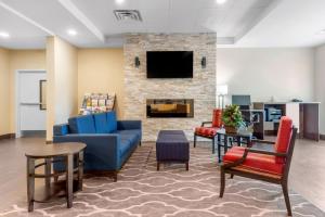 vestíbulo con sofá, sillas y chimenea en Comfort Inn & Suites, en Bowmanville