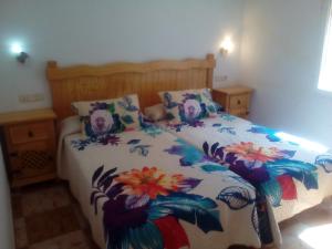 a bedroom with a bed with a floral bedspread at El Molino in Ruidera